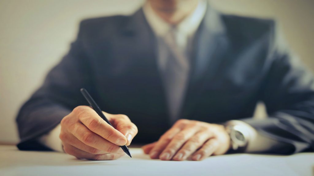 بهترین وکیل طلاق توافقی پشت میز در حال نوشتن است